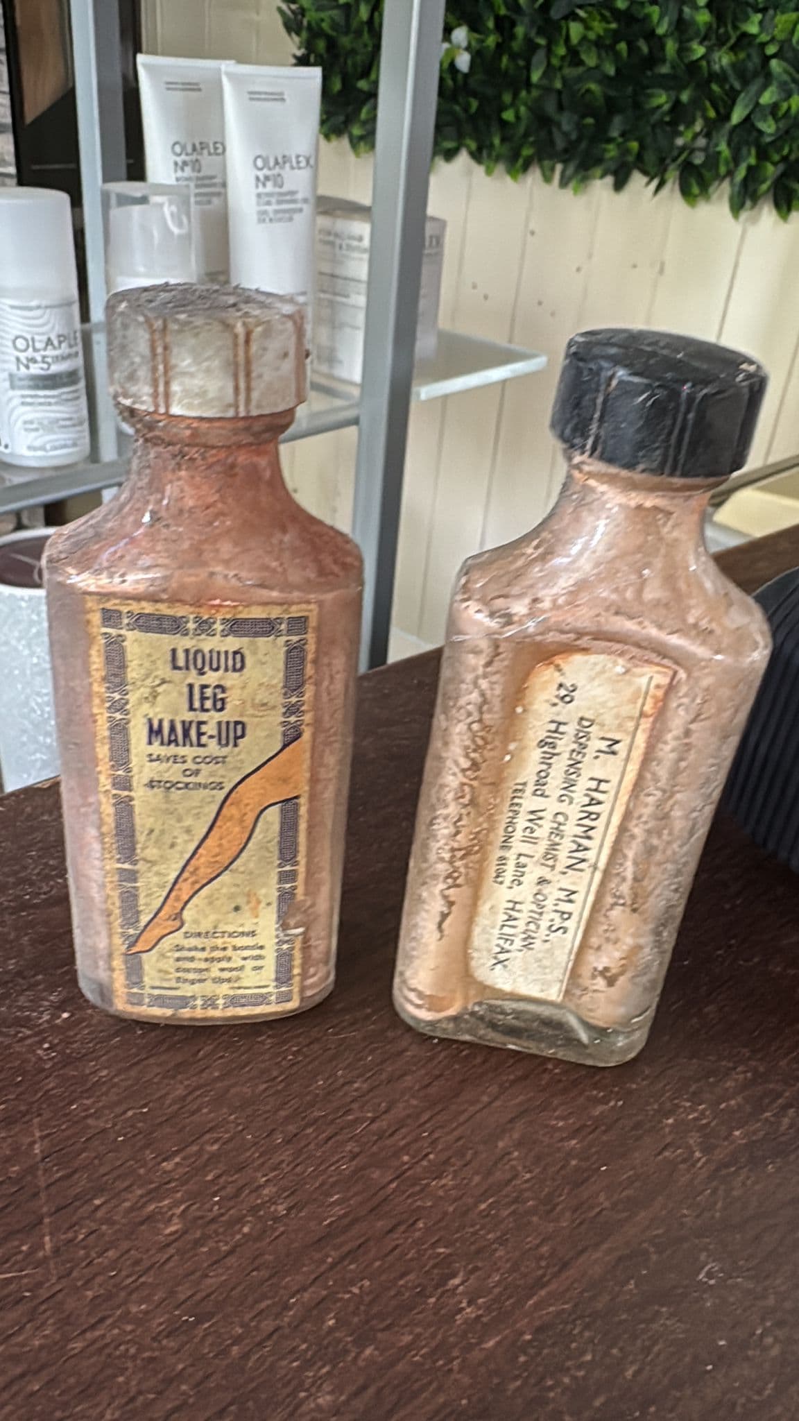 Vintage chemist bottles discovered under the salon floor during a full heating repipe