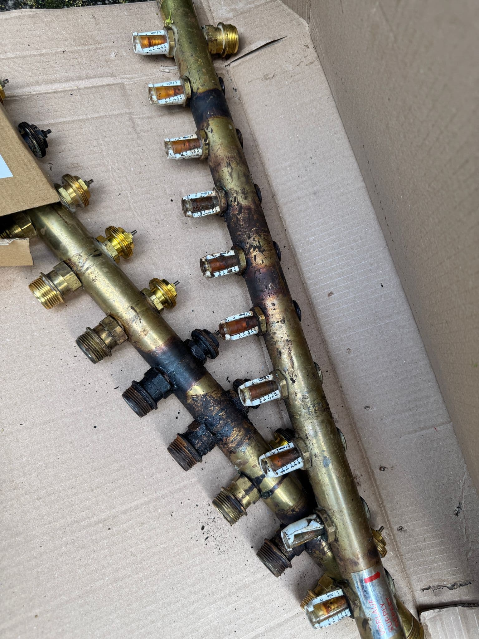 Underfloor heating brass manifold with flow meters removed for repair